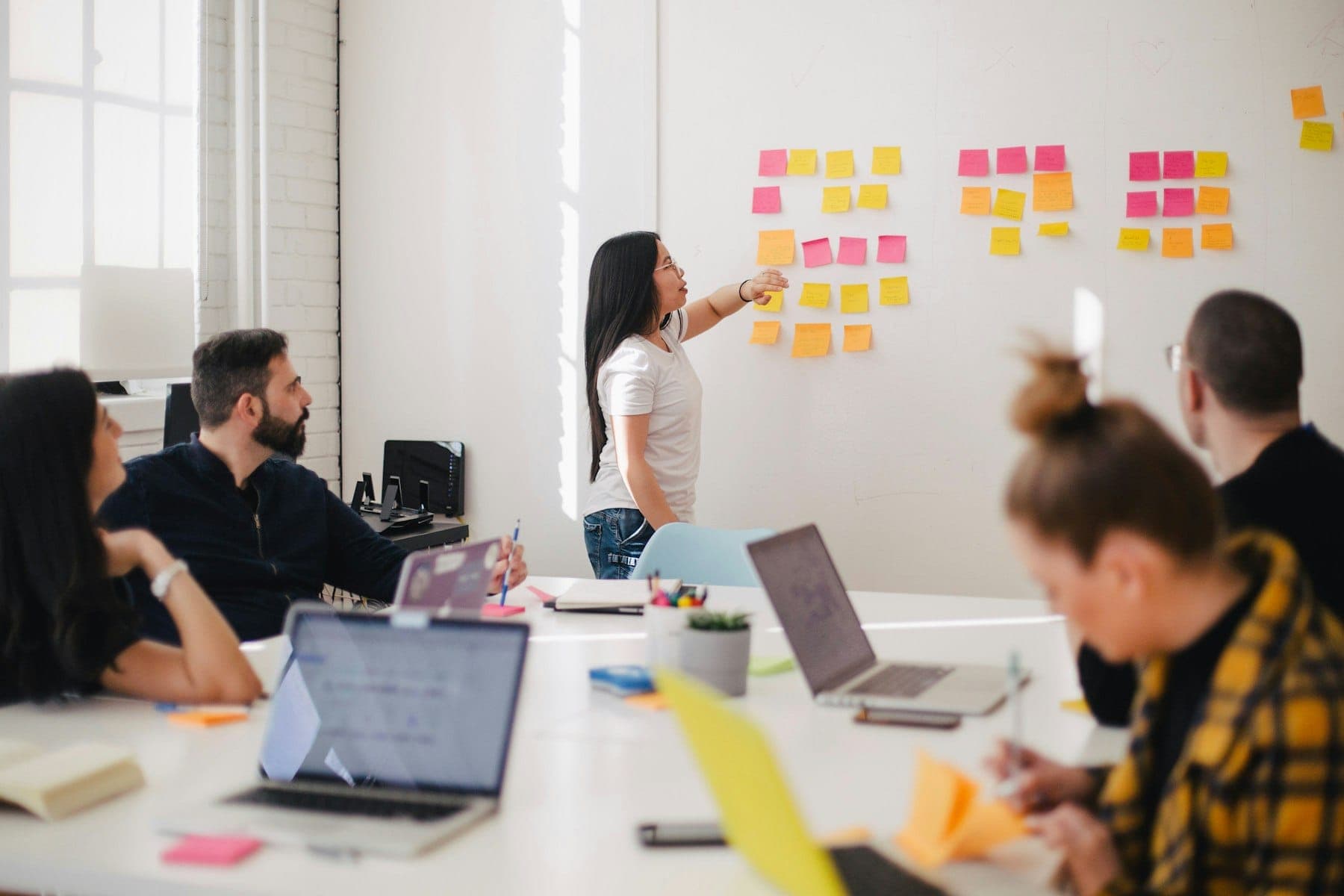 A project team working through a plan together on a wall of notes