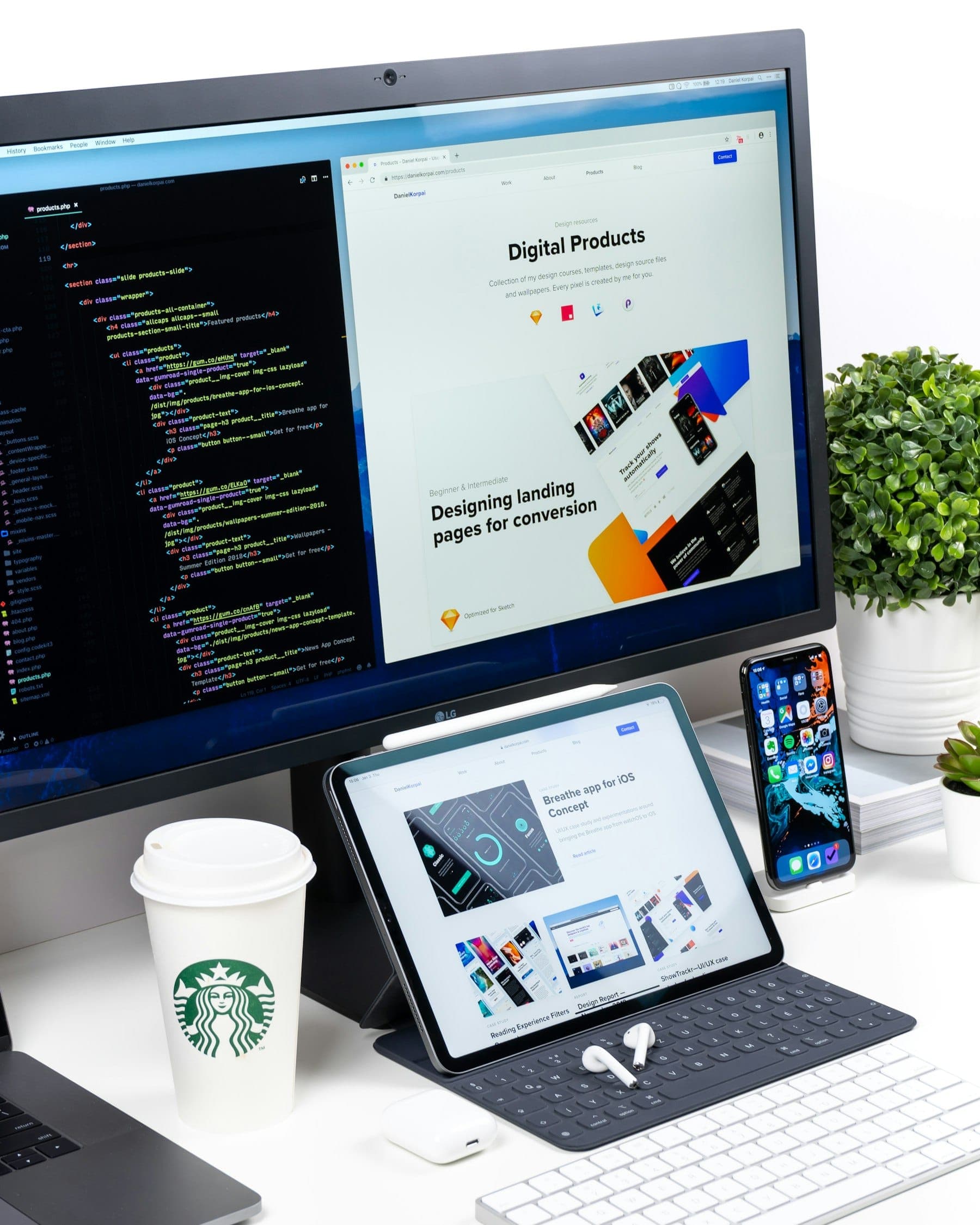 A developer working on a website layout across a laptop and a large monitor